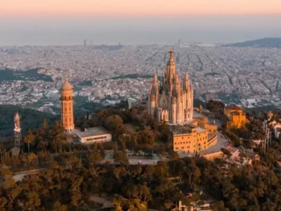 Vista del Tibidabo con su templo en primer plano, y la ciudad de Barcelona extendiéndose al fondo bajo un cielo despejado
