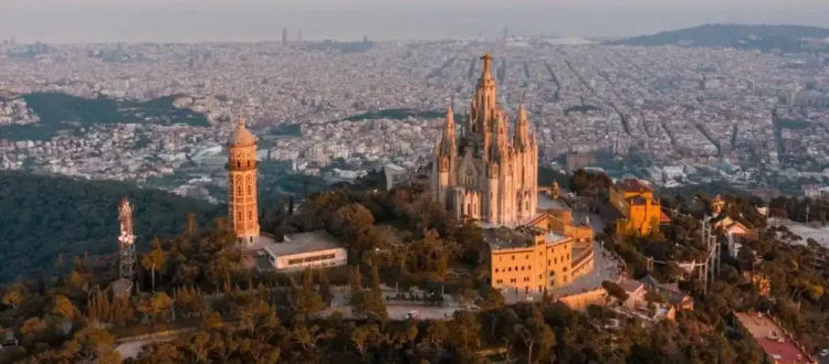 Vista del Tibidabo con su templo en primer plano, y la ciudad de Barcelona extendiéndose al fondo bajo un cielo despejado