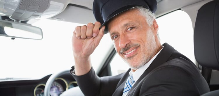 Conductor profesional de LimoluxBCN saludando desde una limusina. Servicio de chófer privado y limusinas en Barcelona