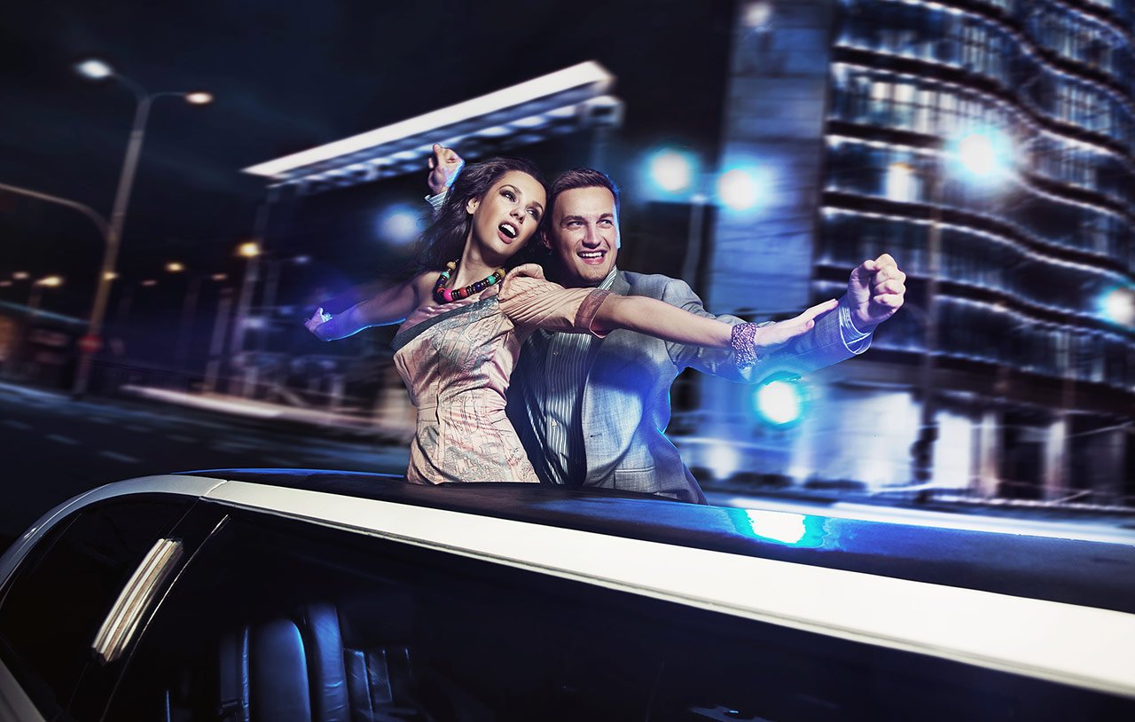 Pareja disfrutando de un paseo en limusina Lincoln Blanca con techo panorámico en Barcelona – LIMO LUX BCN