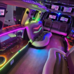 Interior de la limusina con tiras LED rojas en techo y paredes, mostrando un ambiente de estilo lounge.