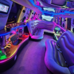 Interior de la limusina con asientos de lujo e iluminación LED azul a lo largo del techo y los laterales.
