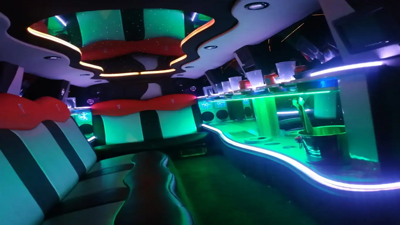 Interior con luces LED verdes de la Limusina Pontiac Premium de LIMO LUX BCN, ambiente festivo y sofisticado en Barcelona