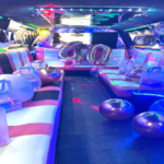 Interior de la limusina Barbie rosa decorada para un cumpleaños de 40 años, con luces y ambiente festivo.