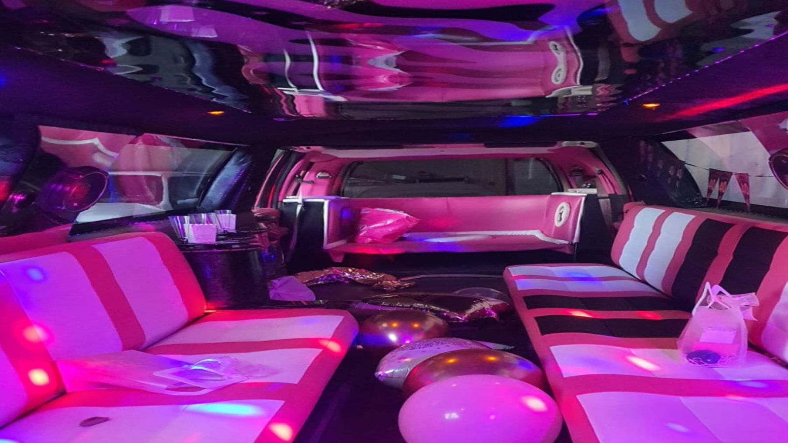 Interior de la limusina Barbie rosa mostrando su sofá cama, un detalle exclusivo del vehículo para mayor confort y estilo.