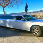 Limusina Chrysler blanca estacionada en una masía durante una celebración de boda.