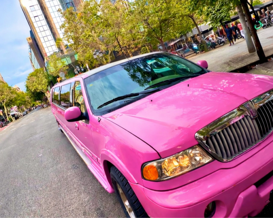 Hummer rosa estilo Barbie con edificios de Barcelona al fondo